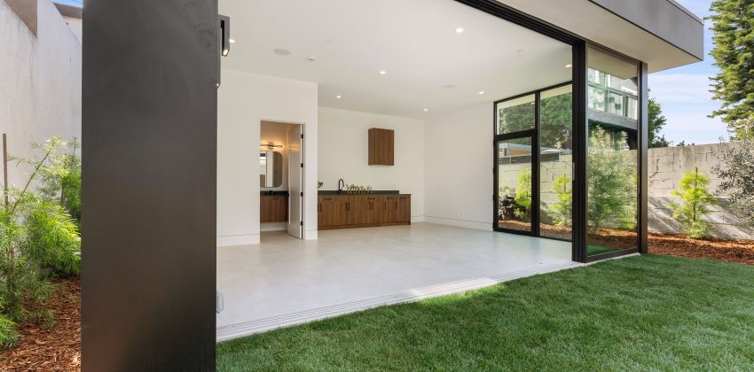 Modern custom home patio with black-framed sliding glass doors and covered outdoor living space in Manhattan Beach, CA